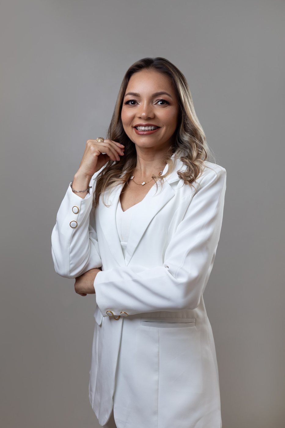 Sileny Reis, terapeuta capilar integrativa, sorrindo, de terno branco